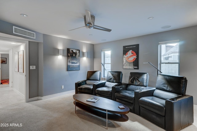 carpeted home theater room with ceiling fan