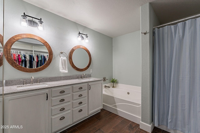 3047 S Mandy St, Mesa, AZ 85212 - bathroom featuring a bath, double vanity, wood finished floors, a shower with curtain, and a textured wall