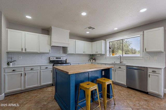 3047 S Mandy St, Mesa, AZ 85212 - kitchen with stainless steel appliances, butcher block countertops, backsplash, white cabinetry, and a kitchen island