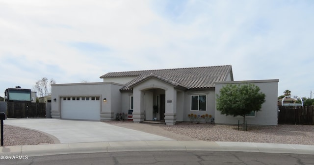 view of front of house featuring a tile roof, stucco siding, an attached garage, fence, and driveway