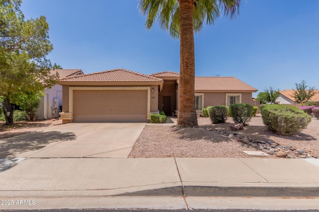 view of front of property featuring a garage, stucco siding, a tile roof, and concrete driveway