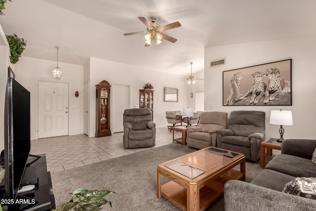 living area featuring a ceiling fan, vaulted ceiling, and tile patterned floors