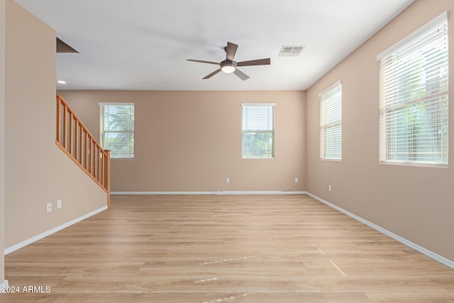 spare room featuring light hardwood / wood-style flooring, ceiling fan, and plenty of natural light