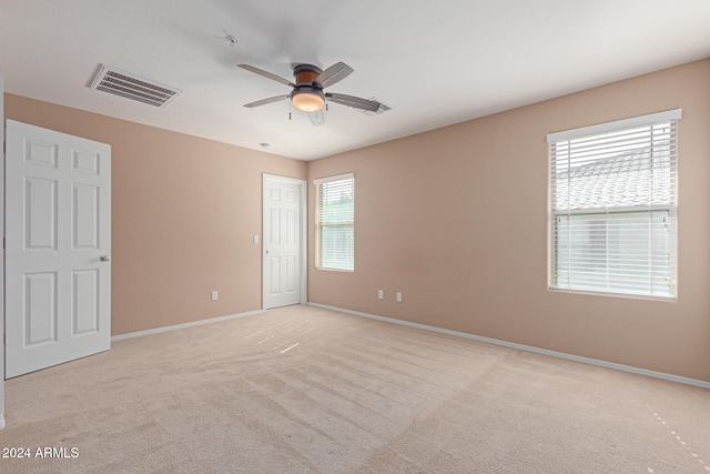 empty room with ceiling fan and light colored carpet