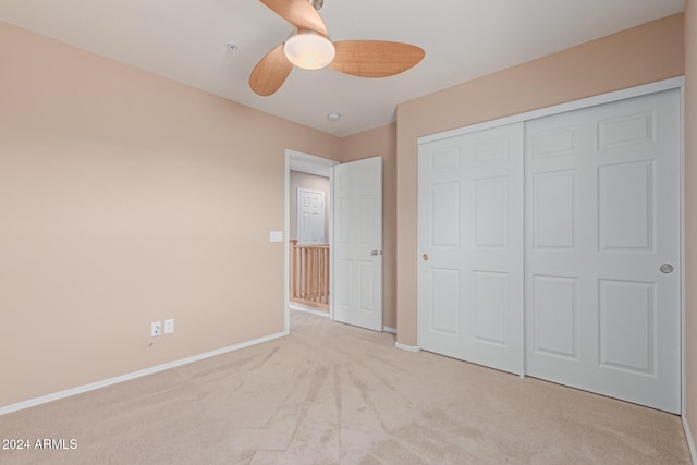 unfurnished bedroom with a closet, light carpet, and ceiling fan