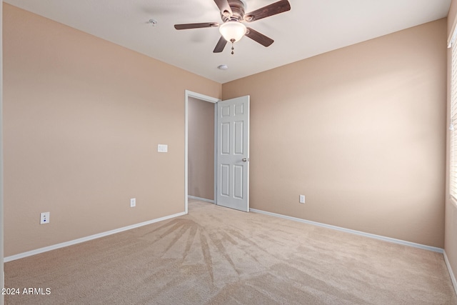 unfurnished room with light colored carpet and ceiling fan