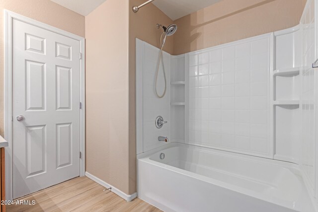 bathroom featuring hardwood / wood-style floors and bathing tub / shower combination