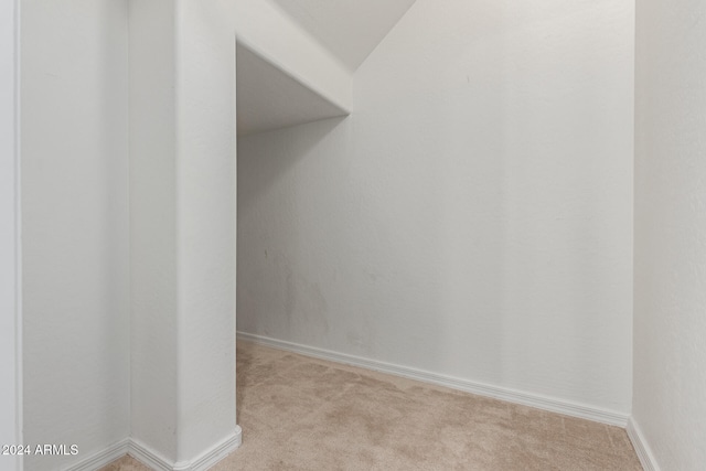 interior space featuring light carpet and lofted ceiling