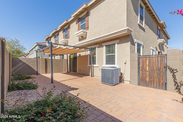 rear view of property featuring central air condition unit, a patio, and a pergola