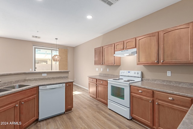 kitchen with sink, hanging light fixtures, light wood-type flooring, and white appliances