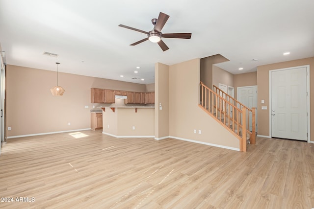 unfurnished living room with light wood-type flooring and ceiling fan