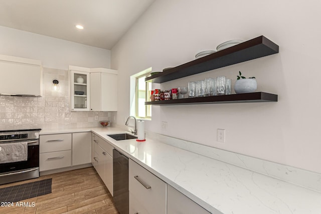 kitchen with sink, light stone counters, stainless steel electric range, black dishwasher, and white cabinets