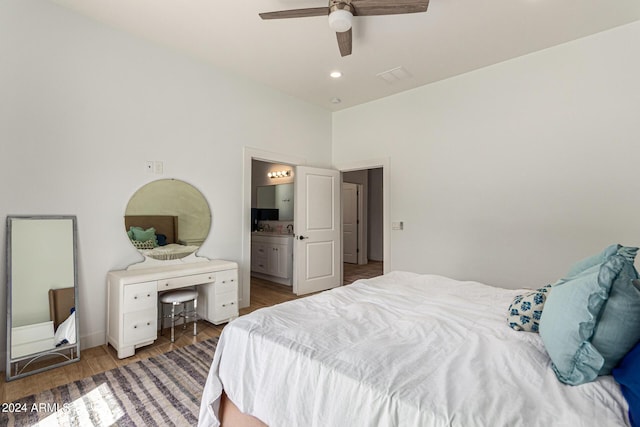 bedroom with wood-type flooring, ceiling fan, and ensuite bath