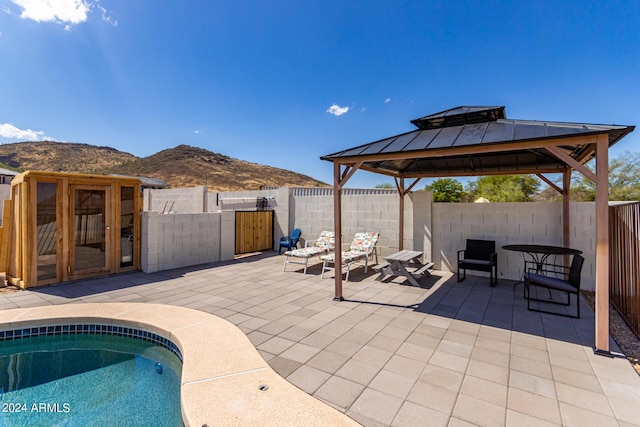 view of swimming pool featuring a mountain view, a gazebo, and a patio