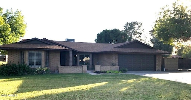 ranch-style home featuring a garage and a front yard