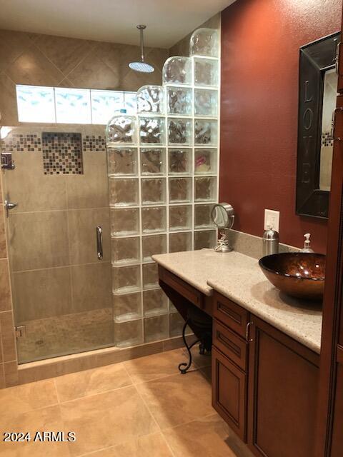 bathroom with tile patterned flooring, vanity, and a shower with shower door