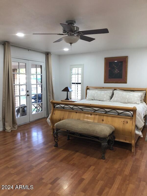 bedroom with ceiling fan, dark wood-type flooring, and access to outside