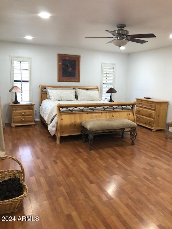 bedroom with ceiling fan and dark hardwood / wood-style flooring