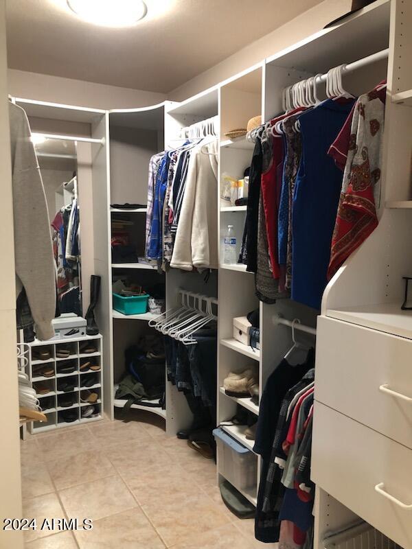 walk in closet with light tile patterned floors