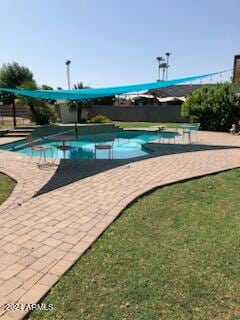 view of pool featuring a lawn