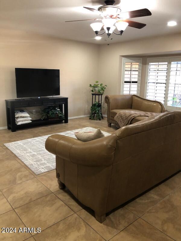 tiled living room featuring ceiling fan