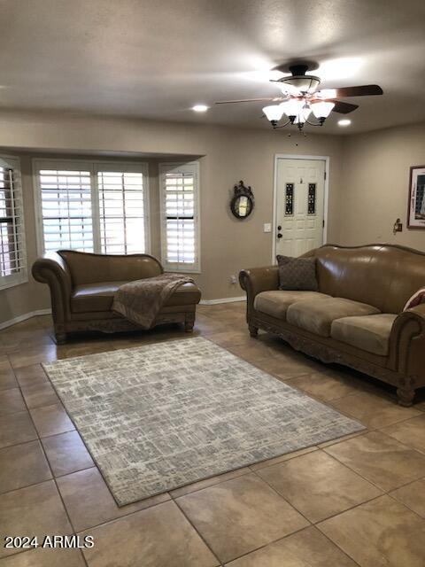 tiled living room with ceiling fan