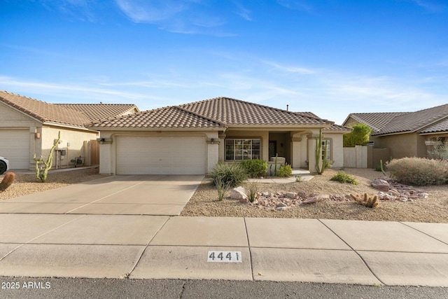 view of front of house with stucco siding, concrete driveway, an attached garage, fence, and a tiled roof