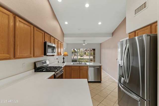 kitchen with light tile patterned floors, stainless steel appliances, light countertops, visible vents, and a peninsula