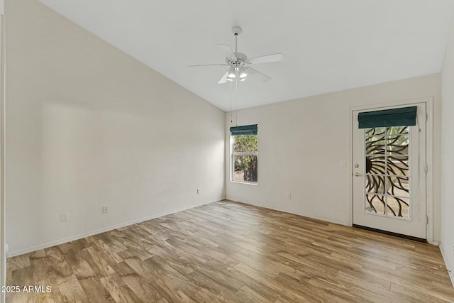 spare room featuring lofted ceiling, light wood-style floors, and a ceiling fan