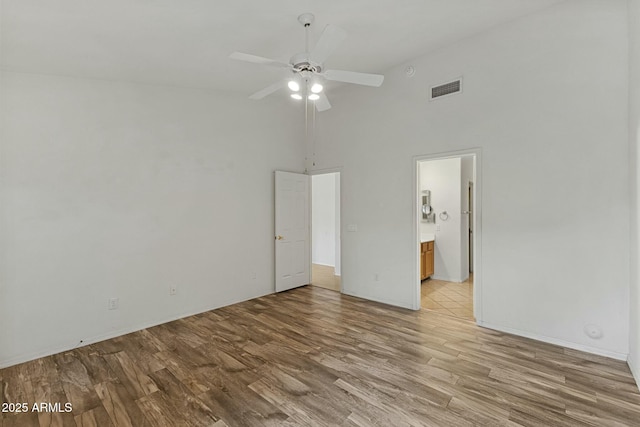 unfurnished bedroom with visible vents, connected bathroom, ceiling fan, high vaulted ceiling, and light wood-type flooring