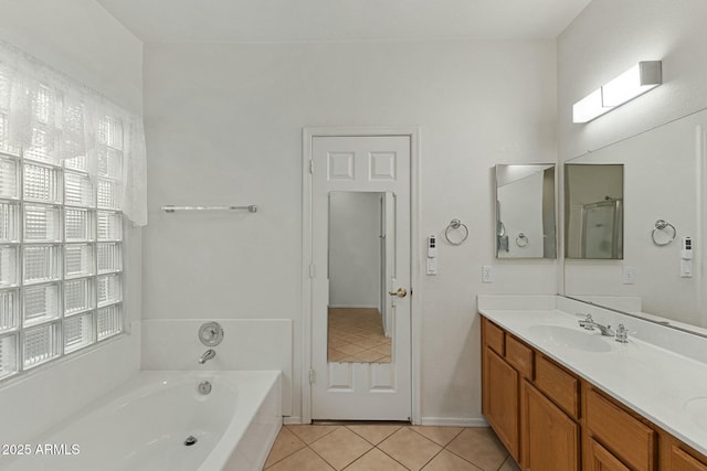 full bathroom with tile patterned floors, a bath, and vanity