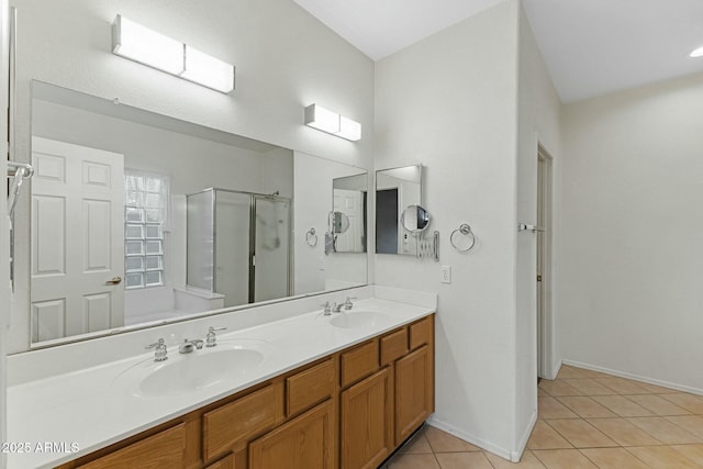 full bath featuring a stall shower, double vanity, a sink, and tile patterned floors