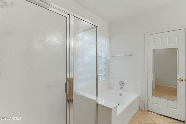 full bathroom featuring tile patterned floors, a garden tub, and a shower stall