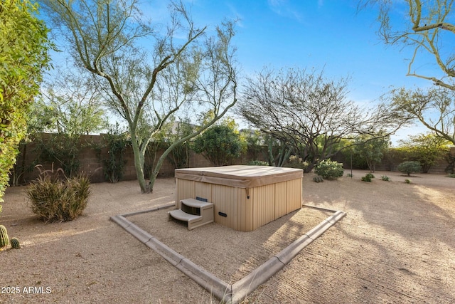 view of yard with a patio area, a fenced backyard, and a hot tub