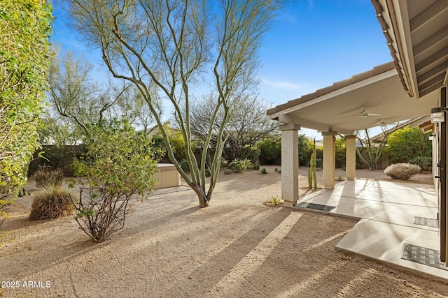 view of yard featuring fence private yard, a patio area, and a ceiling fan