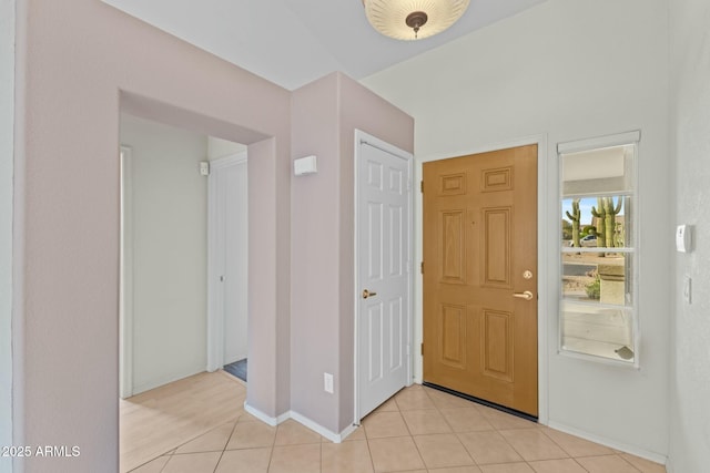 foyer featuring light tile patterned floors and baseboards