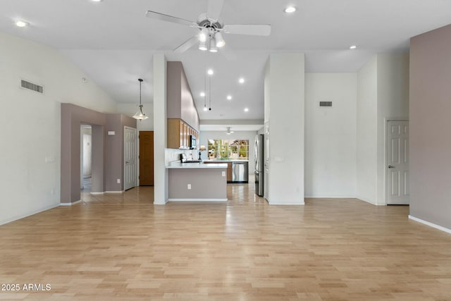 unfurnished living room with high vaulted ceiling, light wood finished floors, visible vents, and a ceiling fan