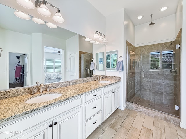 ensuite bathroom with a stall shower, a wealth of natural light, a sink, and ensuite bathroom