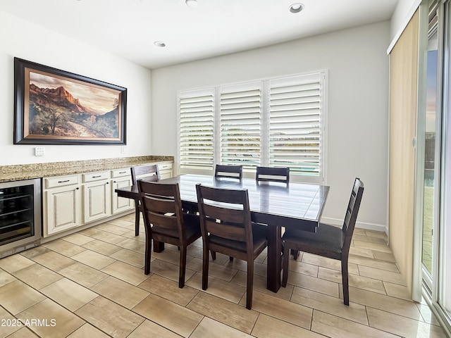dining space with beverage cooler, baseboards, and recessed lighting