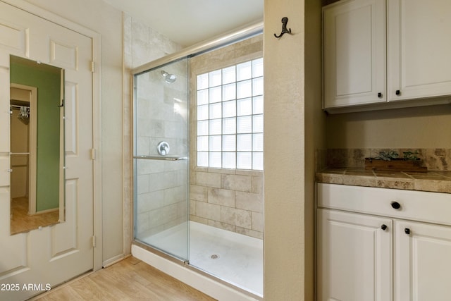 bathroom with hardwood / wood-style flooring and an enclosed shower