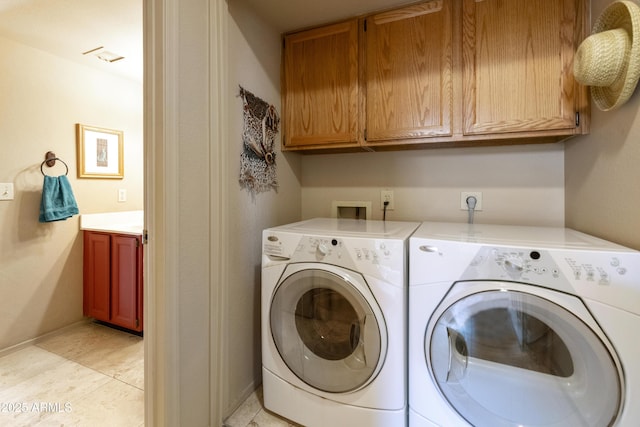 laundry room featuring light tile patterned flooring, cabinets, and washing machine and clothes dryer