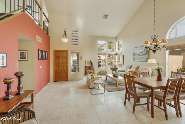 dining space with a towering ceiling, light tile patterned floors, and a notable chandelier