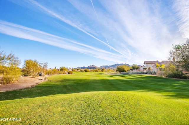 surrounding community with a yard and a mountain view