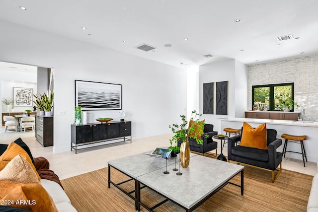 living room featuring sink and light tile patterned floors