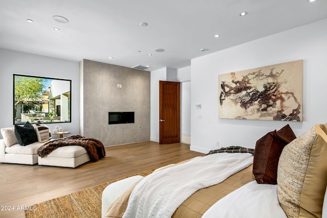 bedroom featuring a fireplace and light wood-type flooring