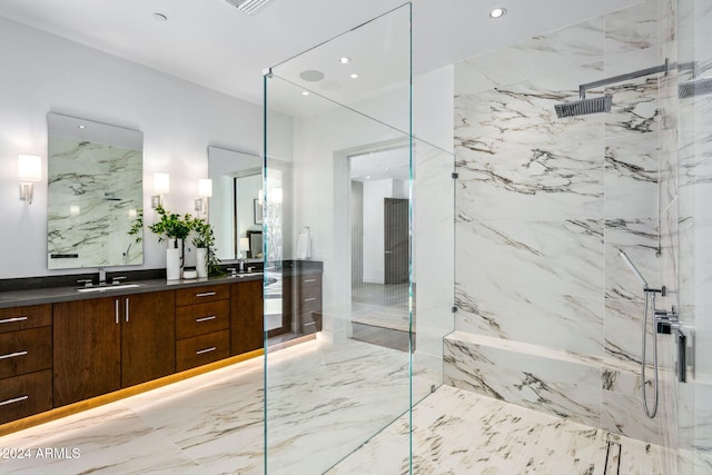 bathroom featuring a tile shower and vanity