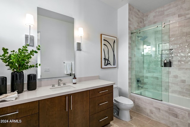 full bathroom featuring tile patterned flooring, vanity, toilet, and bath / shower combo with glass door