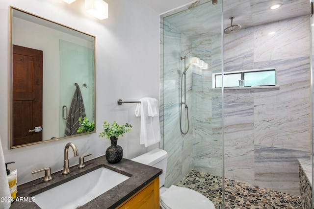 bathroom featuring vanity, toilet, and a shower with door