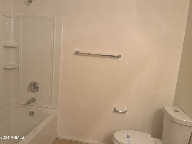 bathroom with tile patterned floors, washtub / shower combination, and toilet