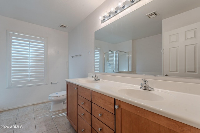 bathroom featuring tile patterned floors, a shower with door, vanity, and toilet